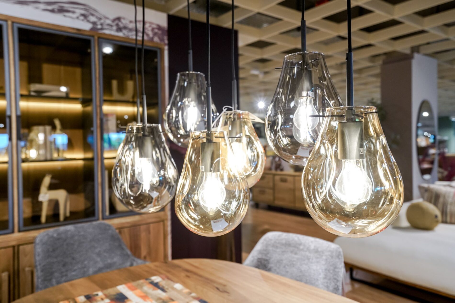 Moderne Hängeleuchten aus Glas über einem Holztisch