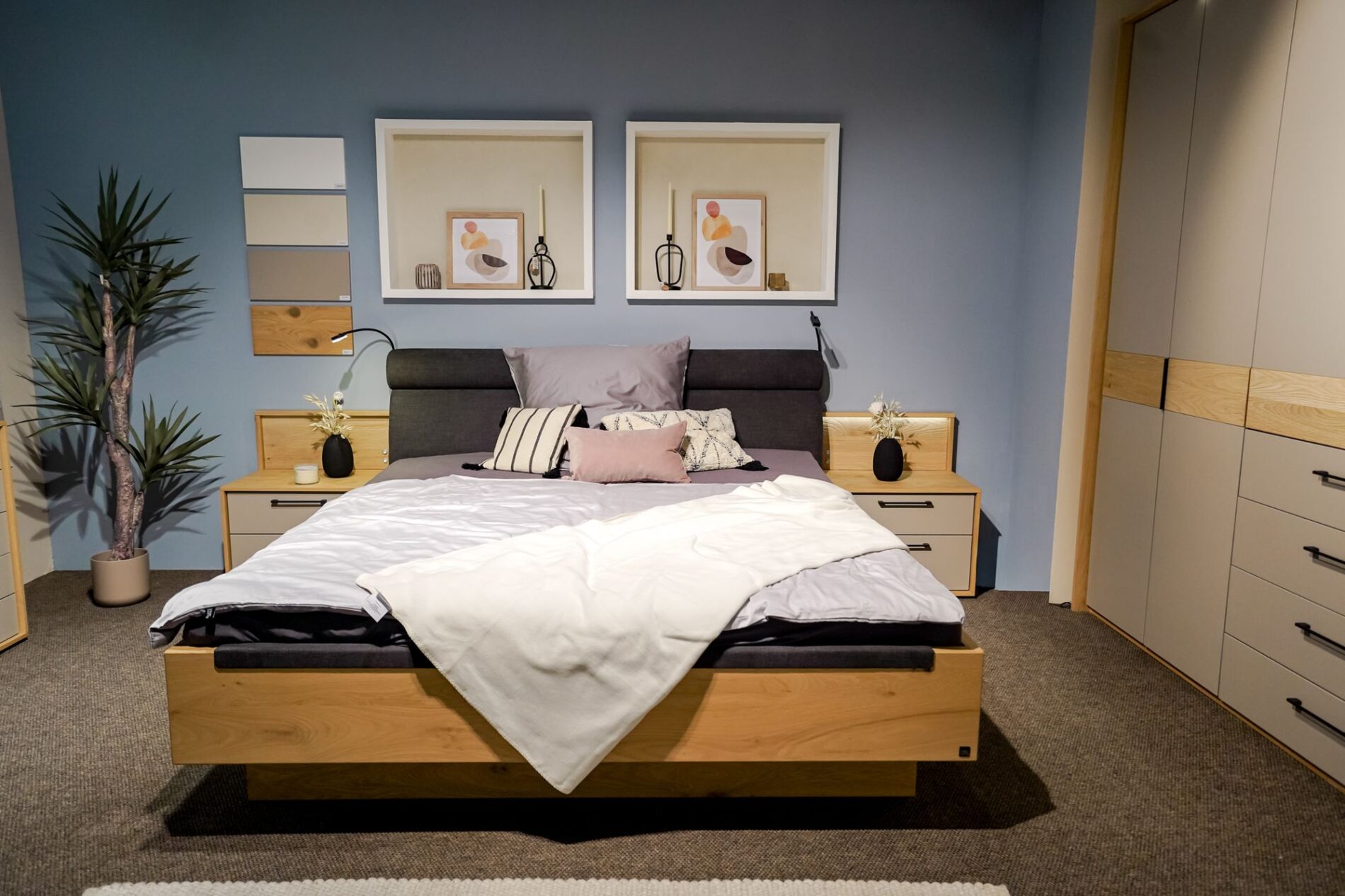 Modernes Schlafzimmer mit Doppelbett, Nachttischen und Kunst an der Wand