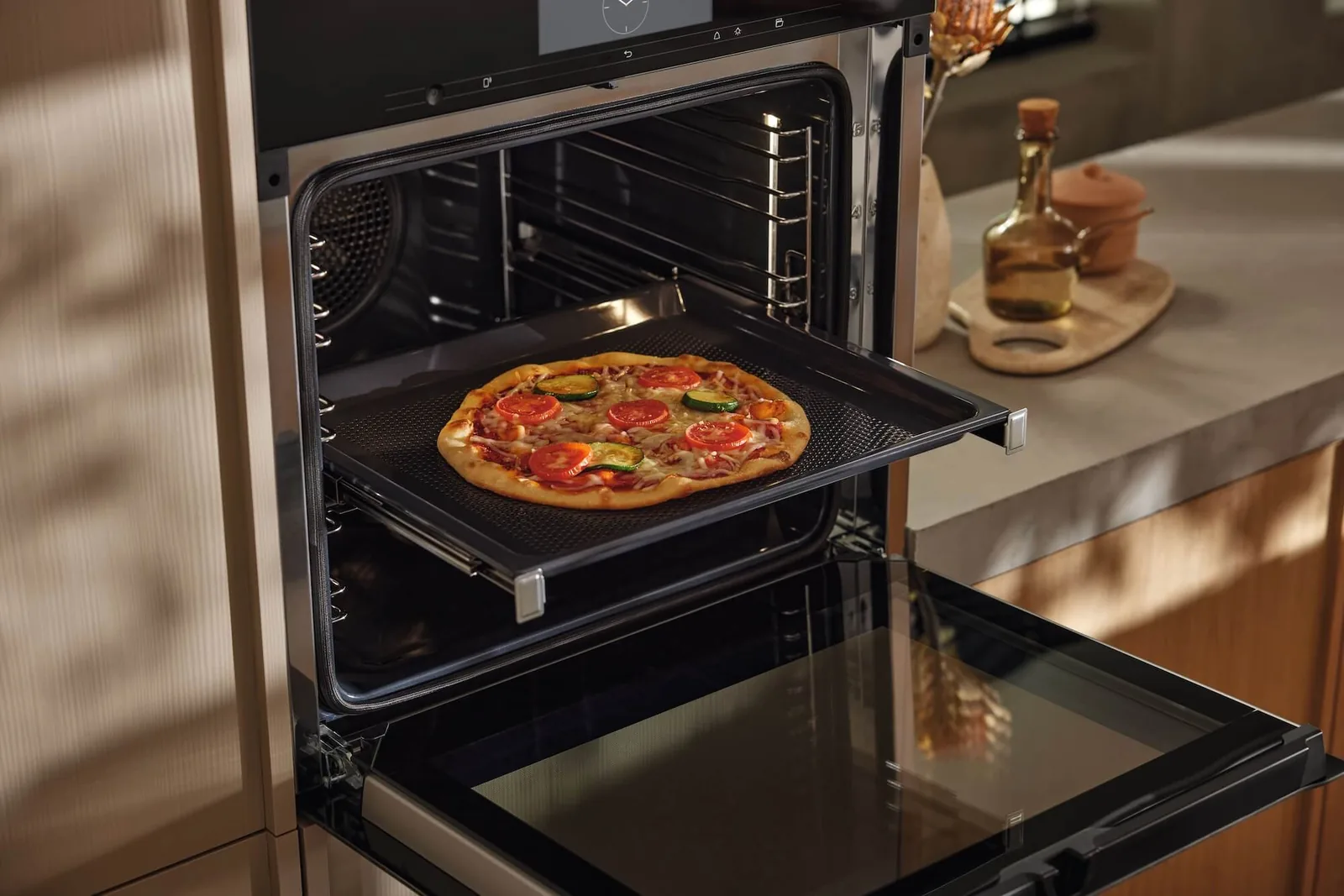 Pizza auf einem Backblech im geöffneten Backofen